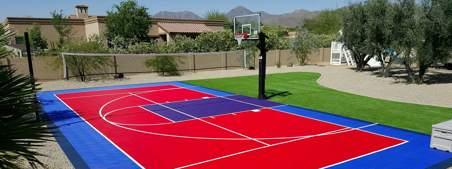 multi court installation with red and blue tiles, surrounded by artificial turf and gravel